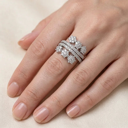 Silver ring with diamonds on a finger against a neutral background