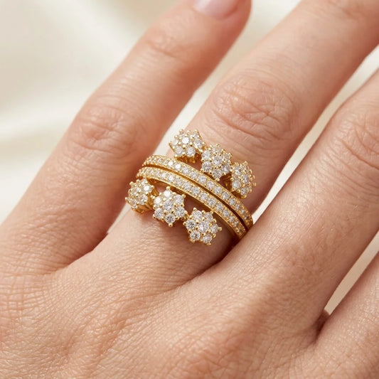 Gold ring with diamonds on a hand against a neutral background