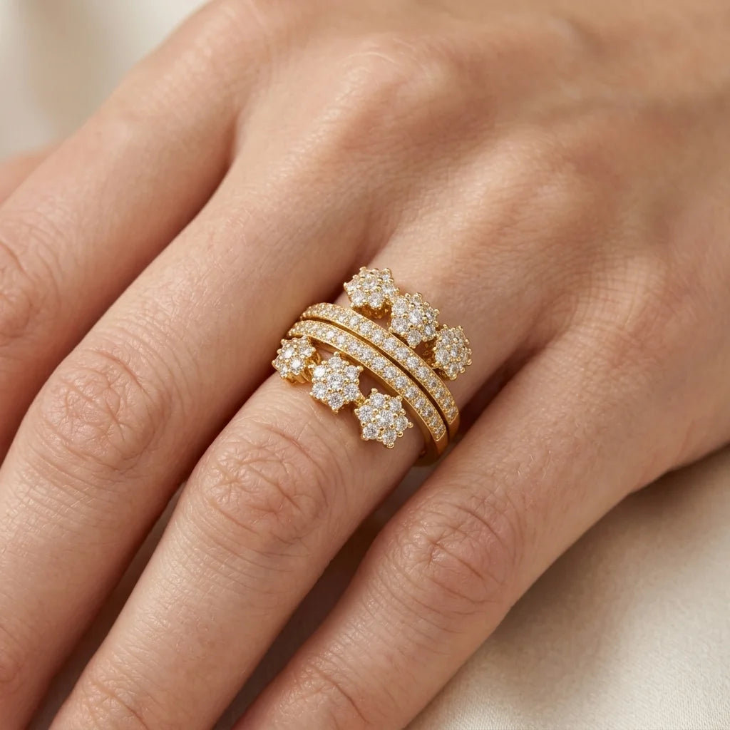Gold ring with diamonds on a person's finger against a neutral background