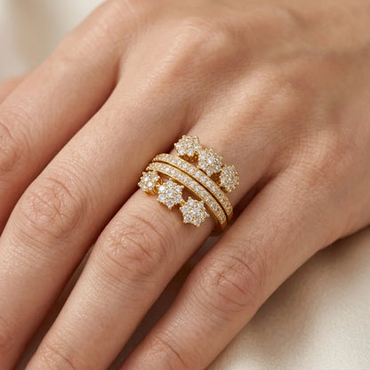 Gold ring with diamonds on a person's finger against a neutral background