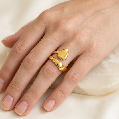Gold ring on a finger against a neutral background