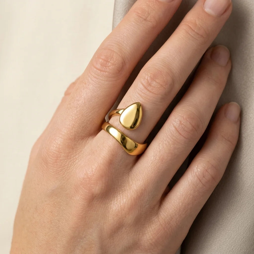 Gold ring on a hand against a neutral background