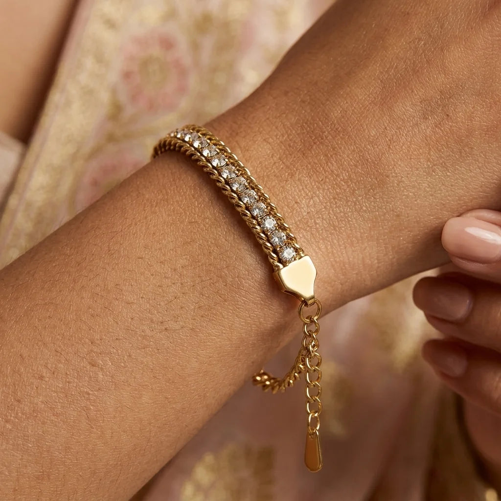 Gold bracelet with a heart-shaped clasp on a wrist against a floral background