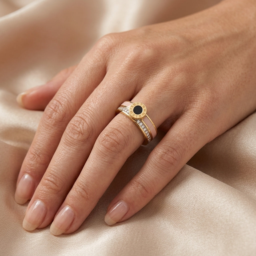 Gold ring with a black gemstone on a hand against a beige fabric background