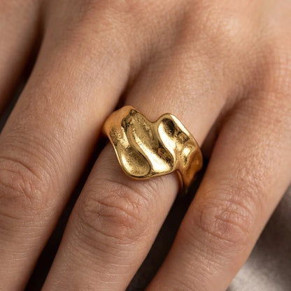 Gold ring on a finger with a blurred background