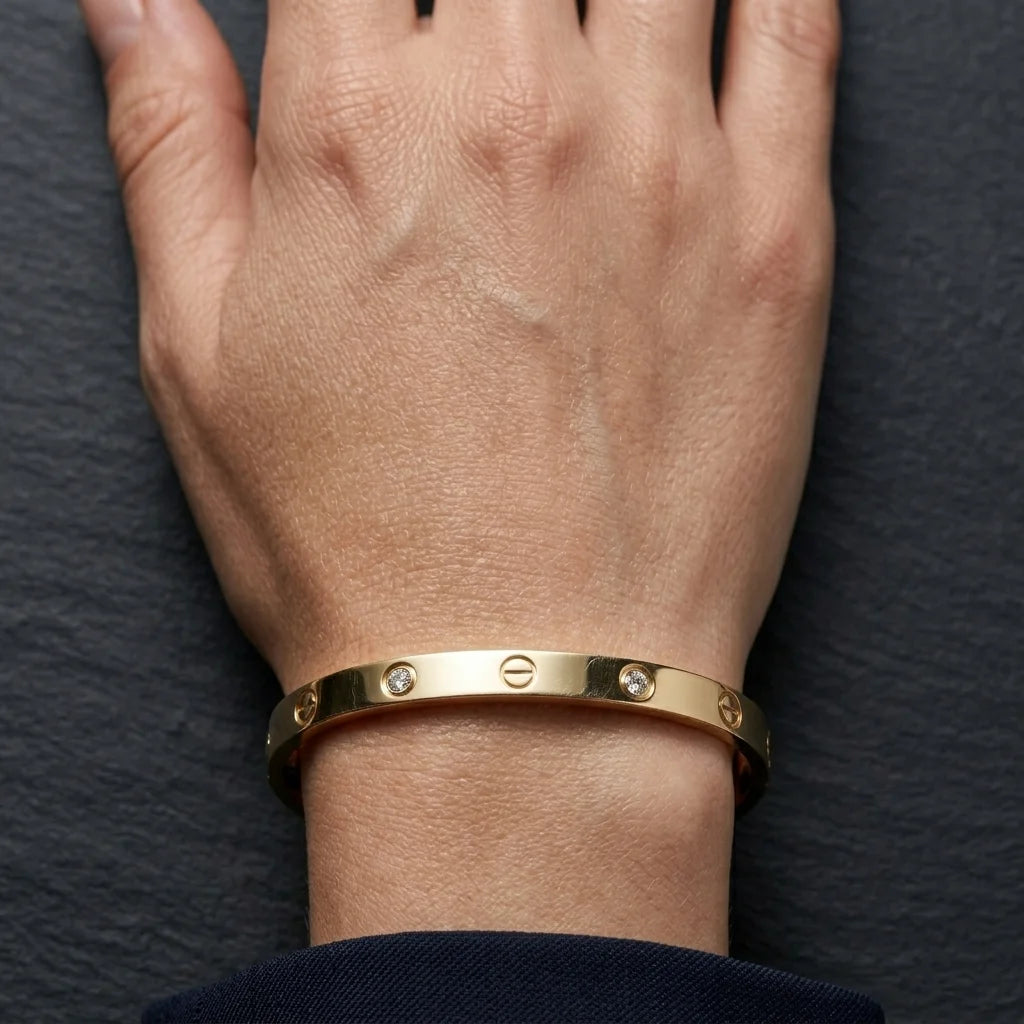 Gold bracelet on a wrist against a dark background