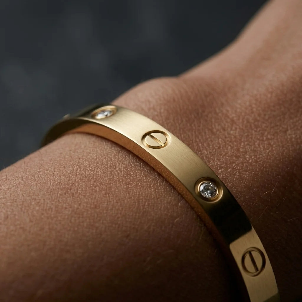 Gold bracelet with diamonds on a wrist against a dark background
