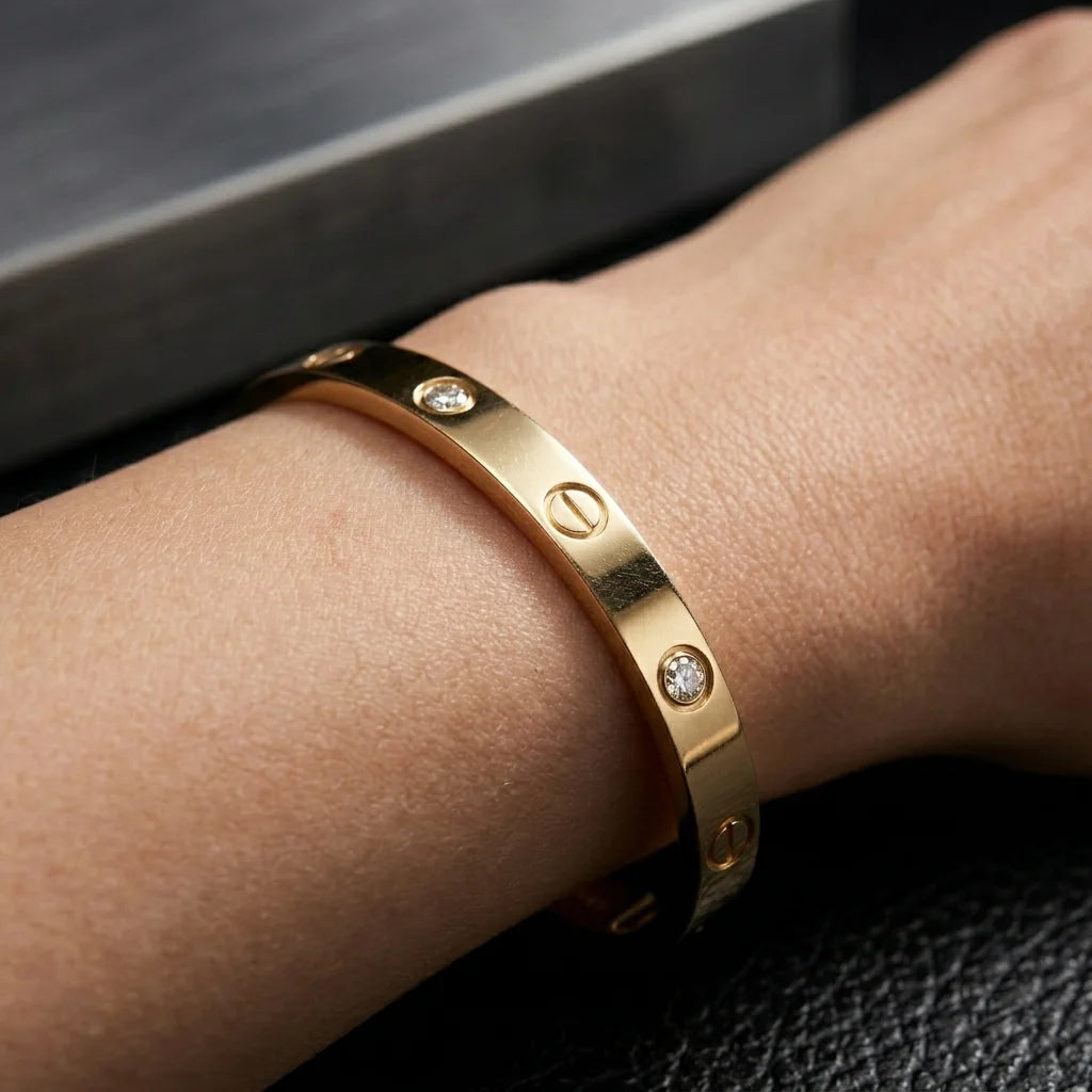 Gold bracelet with diamond accents on a wrist against a dark background