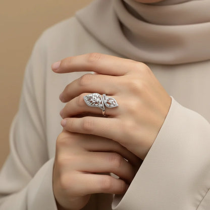 Hand wearing a decorative ring with a beige background