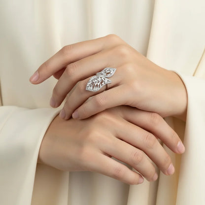 Close-up of a hand wearing a diamond ring with a soft beige background