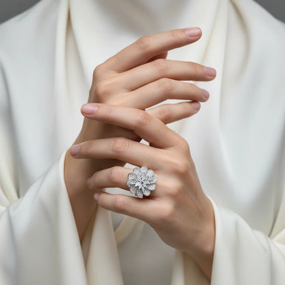 Hand wearing a diamond ring with a white garment in the background
