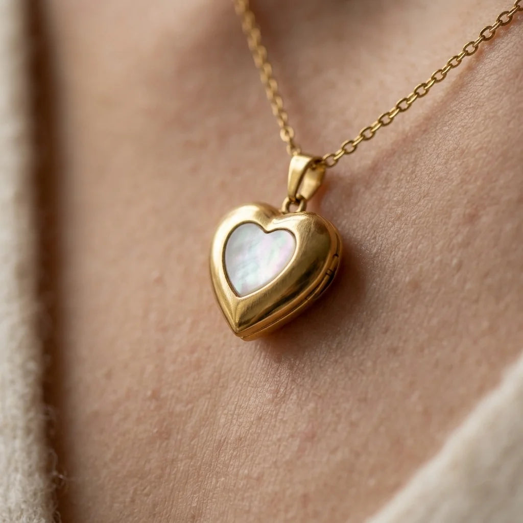 Gold heart-shaped necklace with a light-colored stone on a person's neck.