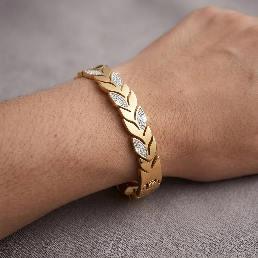 Gold bracelet with diamond accents on a wrist against a gray background