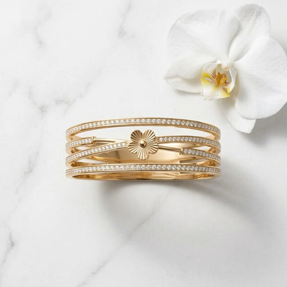 Gold bracelet with diamond accents on a white marble surface with a white orchid.
