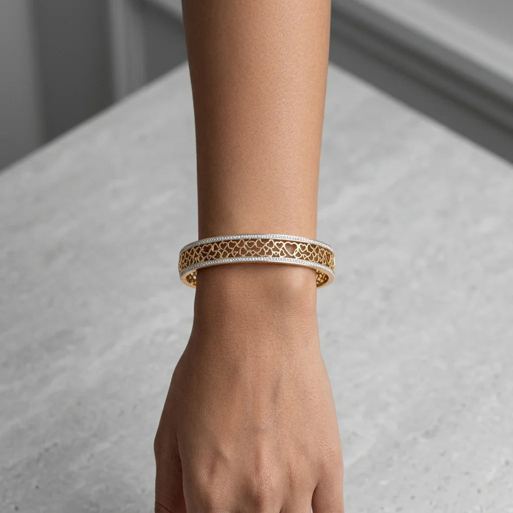 Hand wearing a gold bracelet on a neutral background