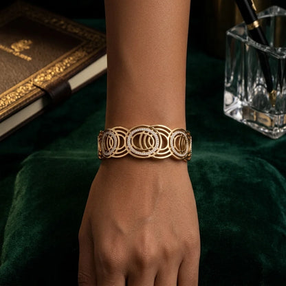 Gold bracelet on a wrist with a dark background