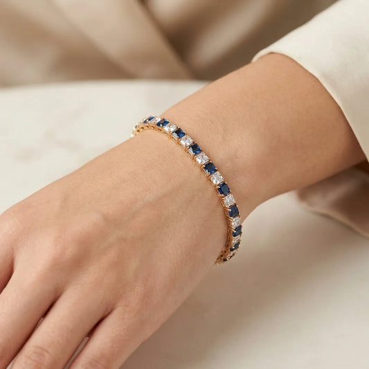 Close SHOT of a hand wearing a gold bracelet with blue and white stones.