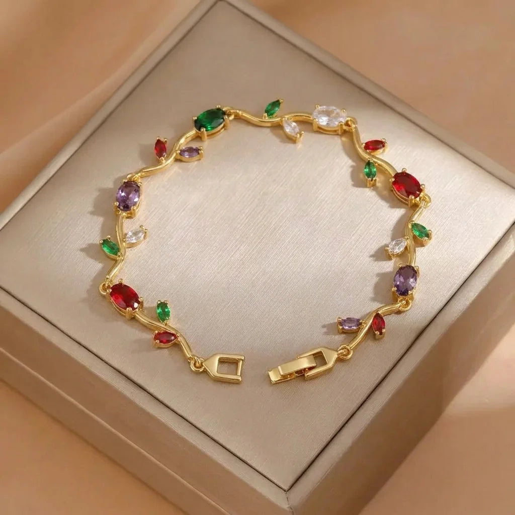 Gold bracelet with colorful gemstones on a beige box