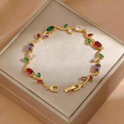 Gold bracelet with colorful gemstones on a beige box