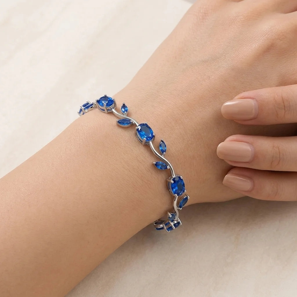 Bracelet with blue gemstones on a wrist against a neutral background