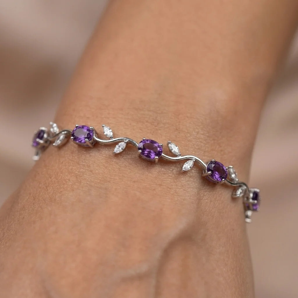 Silver bracelet with purple gemstones on a wrist against a neutral background