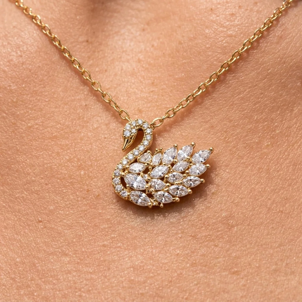 Gold necklace with a swan-shaped pendant on a skin background
