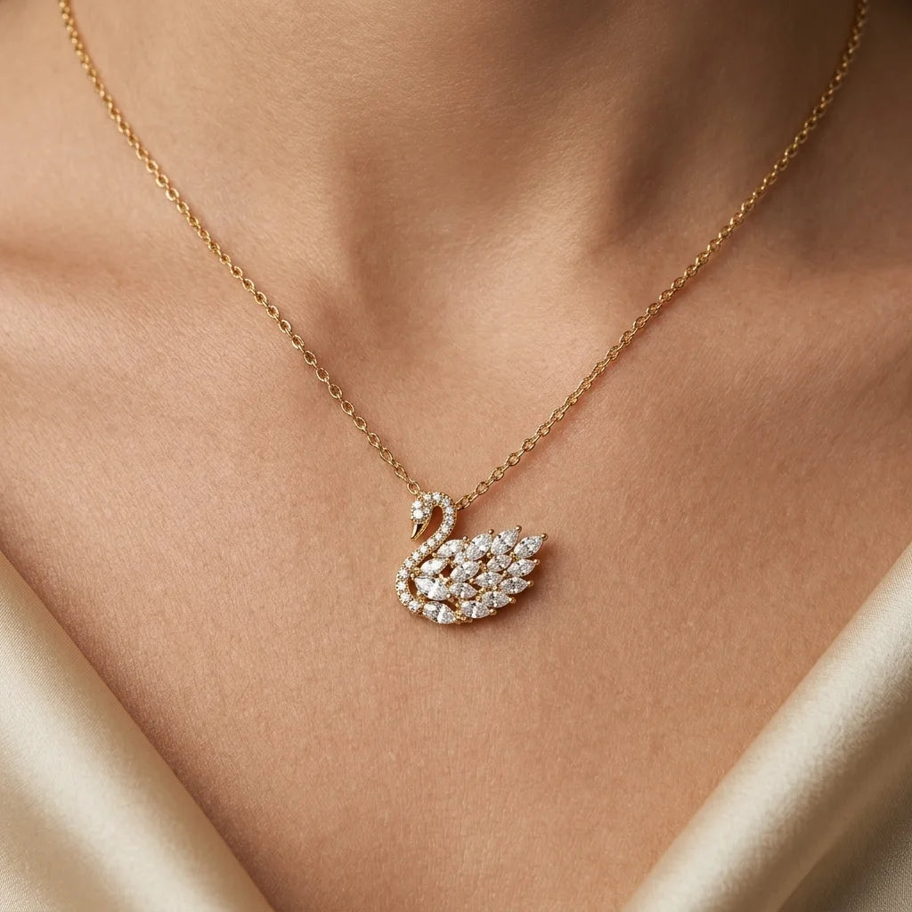 Gold necklace with a swan-shaped pendant on a person's neck