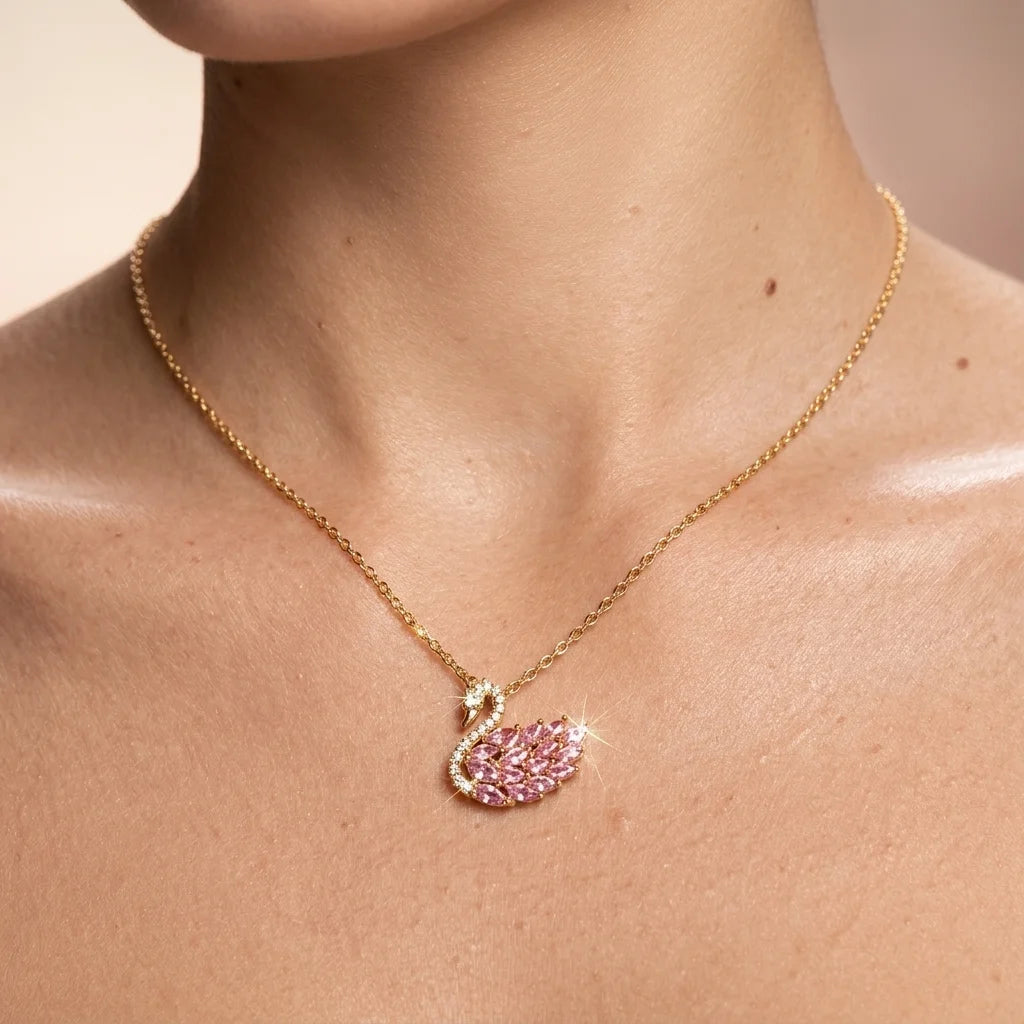 Gold necklace with a pink leaf-shaped pendant on a person's neck