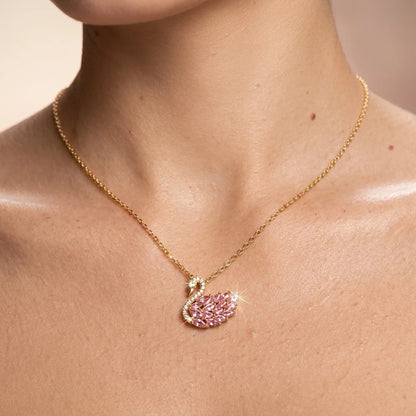 Gold necklace with a pink leaf-shaped pendant on a person's neck