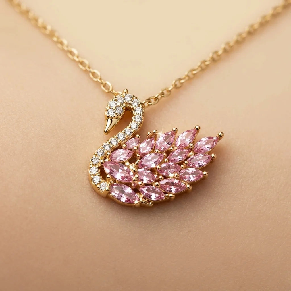 Gold necklace with a swan pendant featuring pink gemstones on a beige background