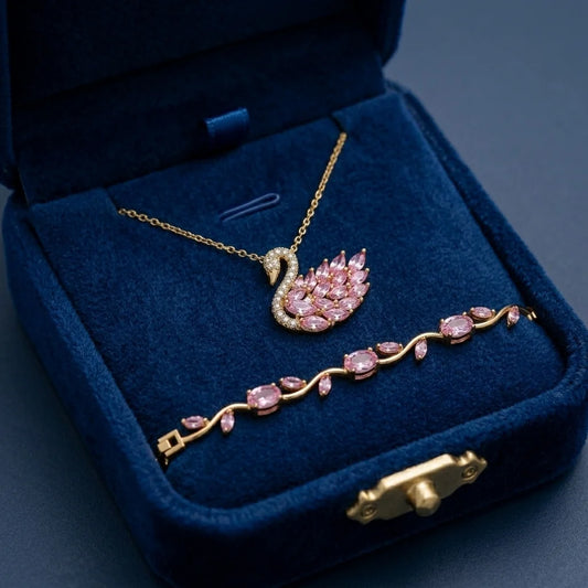 Gold and pink gemstone Swan necklace and bracelet set in a blue jewelry box.