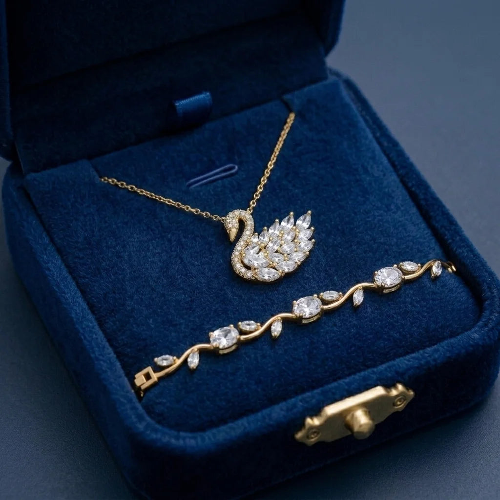 Gold swan necklace and bracelet set in a blue jewelry box