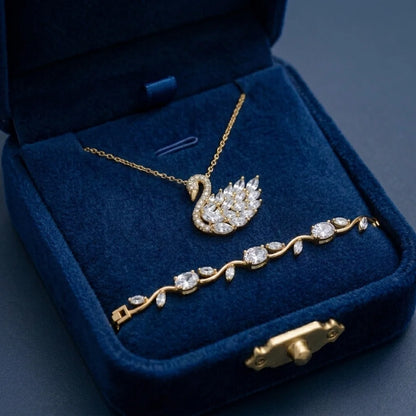 Gold swan necklace and bracelet set in a blue jewelry box