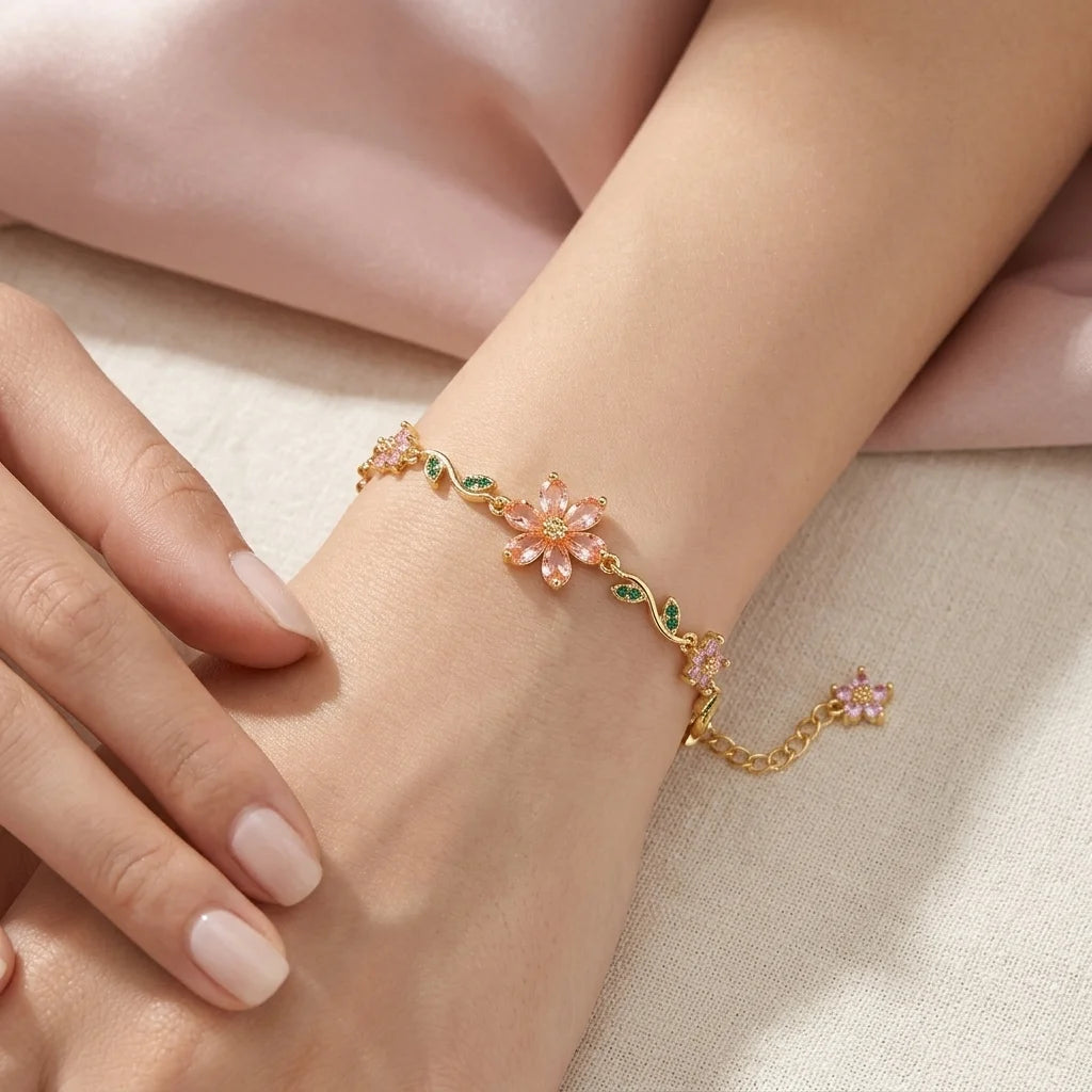 Delicate gold bracelet with floral designs on a wrist against a soft background