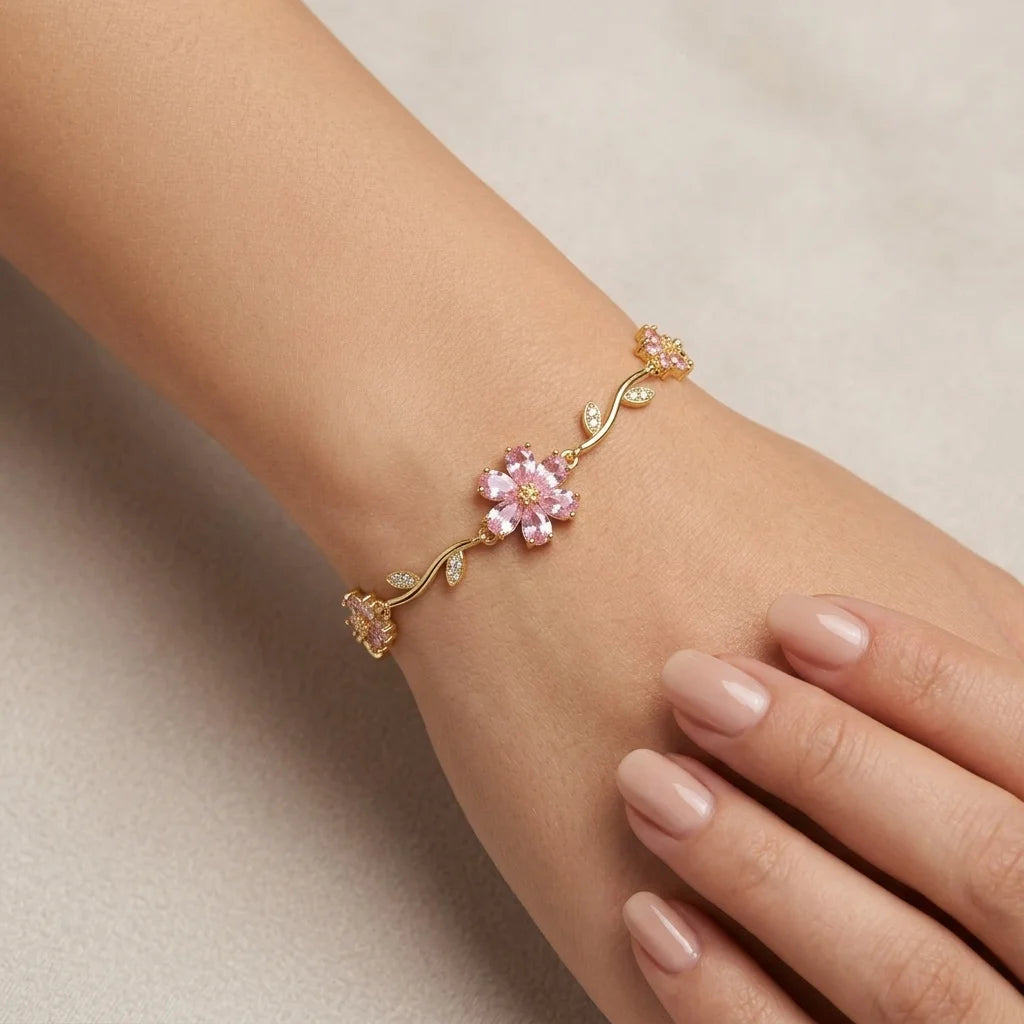 Delicate bracelet with pink floral design on a wrist against a neutral background