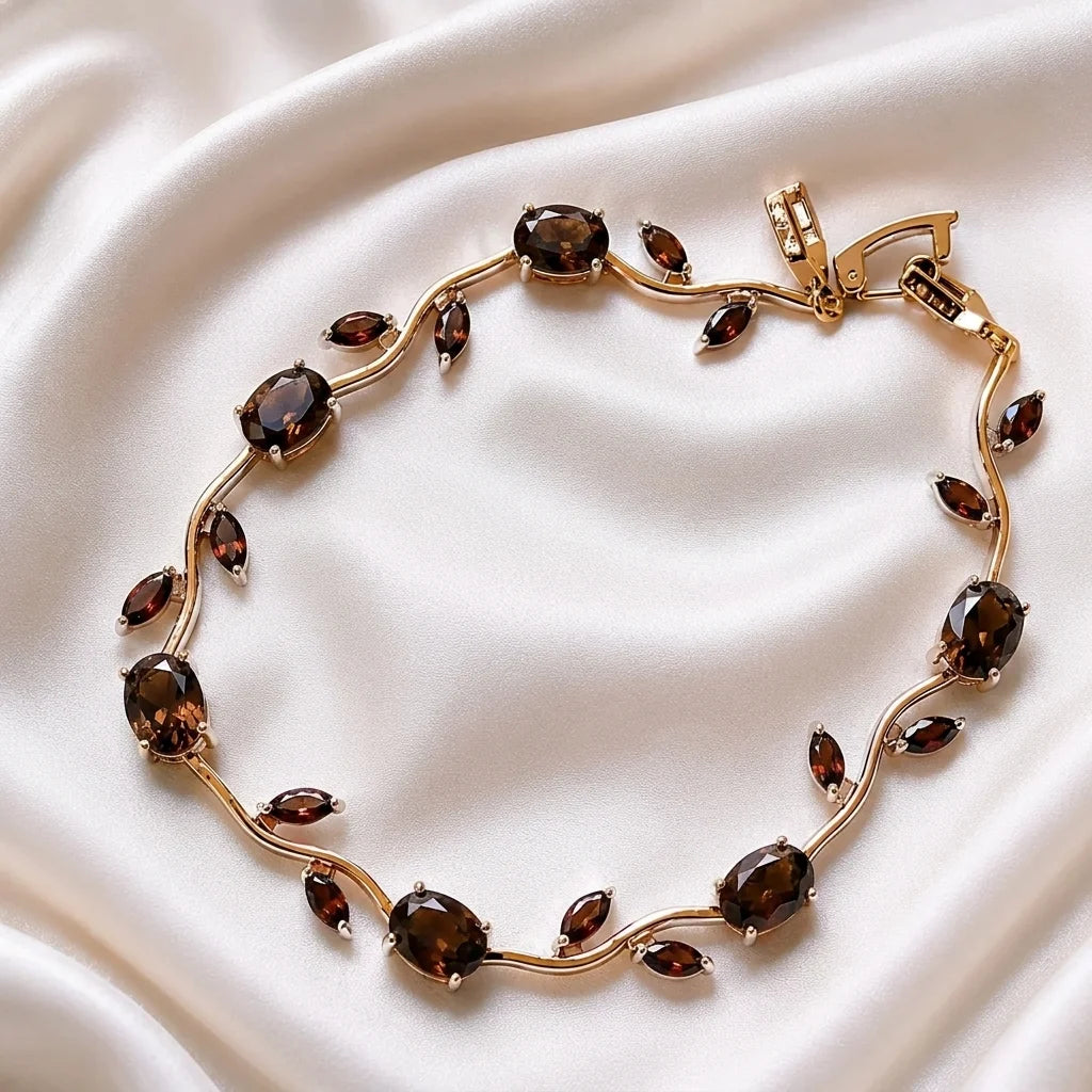 Gold bracelet with brown gemstones on a white fabric background