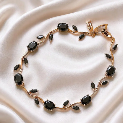 Gold bracelet with blue gemstones on a beige fabric background