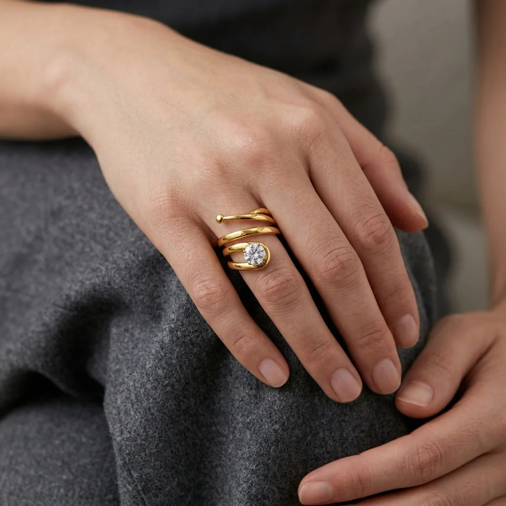 Modern spiral gold ring design with polished finish and sparkling diamond accent.