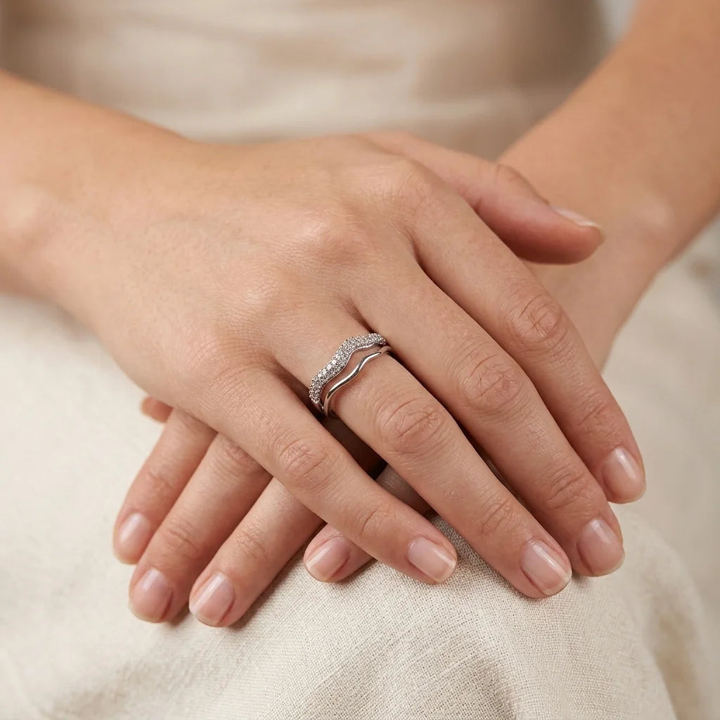 UPT silver pavé wave ring stacked with a polished wave band, worn on hand against cream linen