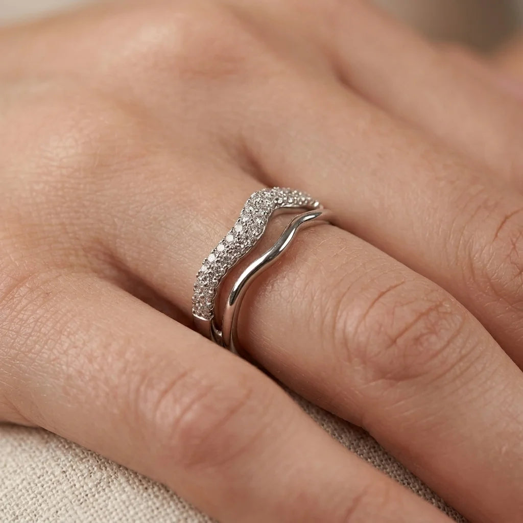 Close-up of UPT ring showing pavé-set crystals on a silver-tone wave band
