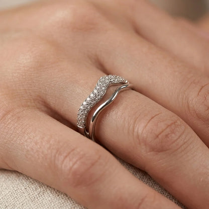 Close-up of UPT ring showing pavé-set crystals on a silver-tone wave band