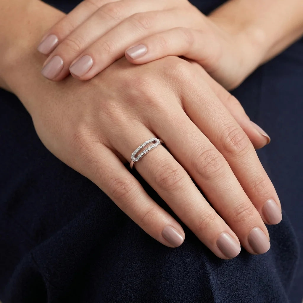 Elegant white gold ring featuring open oval design and round‑cut stones.