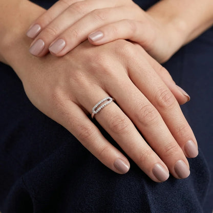 Elegant white gold ring featuring open oval design and round‑cut stones.