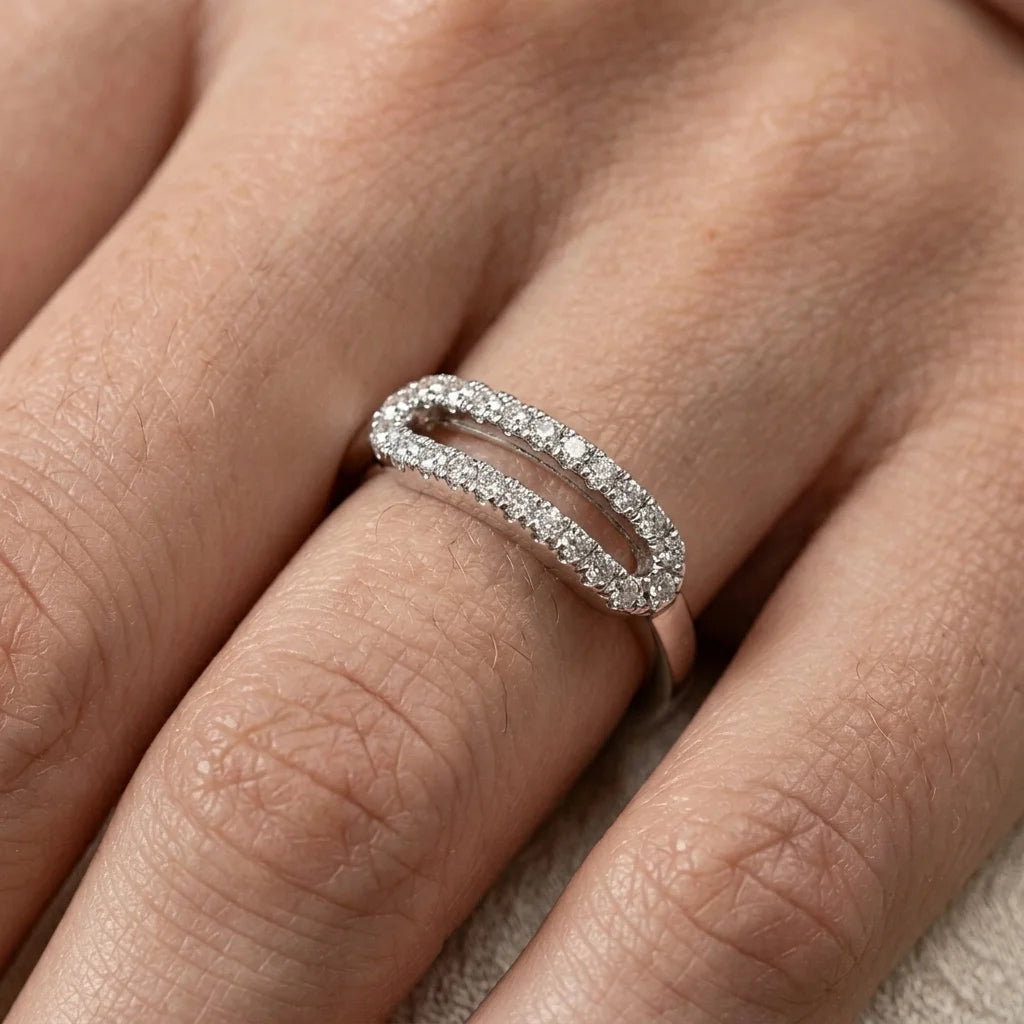 Close‑up of a silver oval ring with two rows of sparkling diamonds.