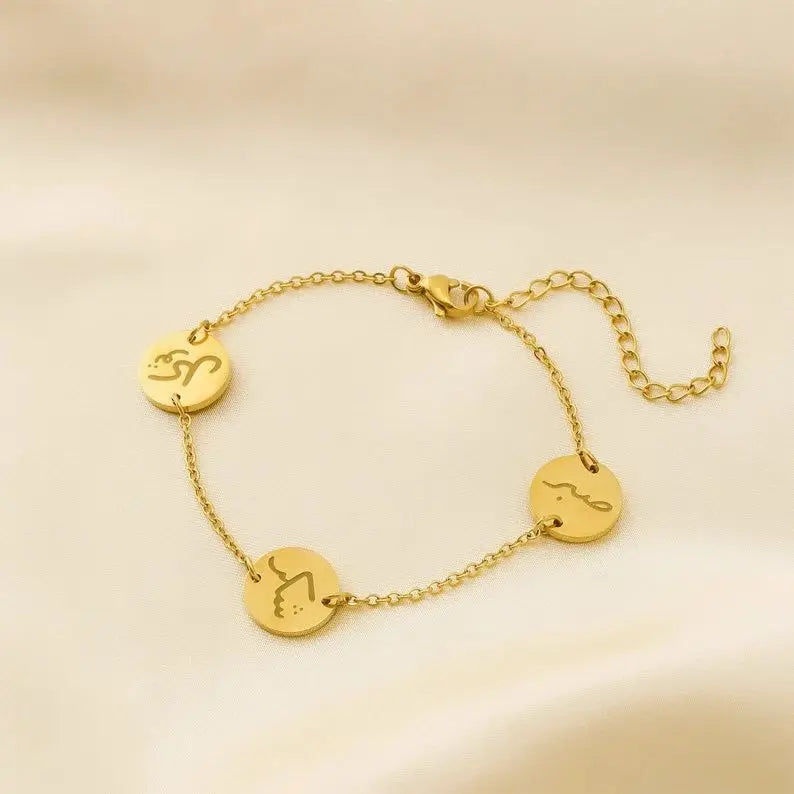 Gold bracelet with circular pendants on a beige background
