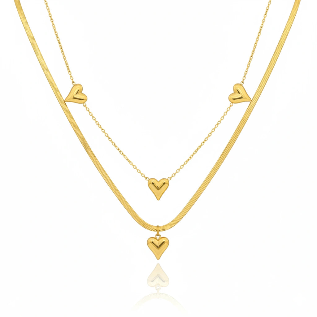 Two gold necklaces with heart pendants on a white background