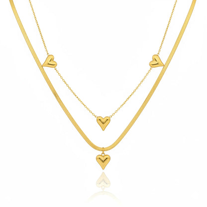 Two gold necklaces with heart pendants on a white background