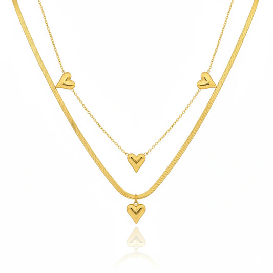 Two gold necklaces with heart pendants on a white background