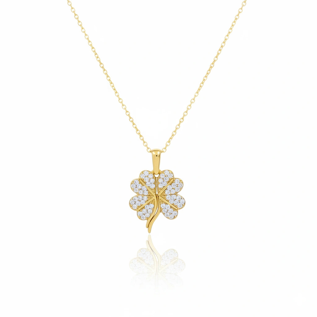Gold necklace with a four-leaf clover pendant on a white background