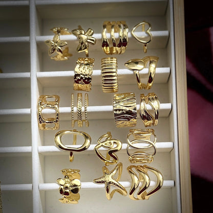 Collection of gold earrings displayed on a white rack.
